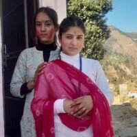 Two friends playing Holi with bright colors