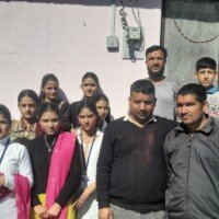 Team members celebrating Holi festival outdoors